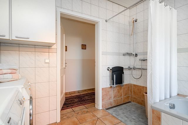 Badezimmer mit ebenerdiger Dusche und Wanne